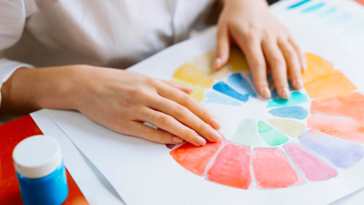 Cilvēks sēž pie uzgleznota krāsu apļa