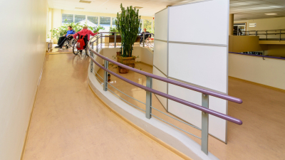 Personas ratiņkrēslos pārvietojas pa uzbrauktuvi SIVA koledžā